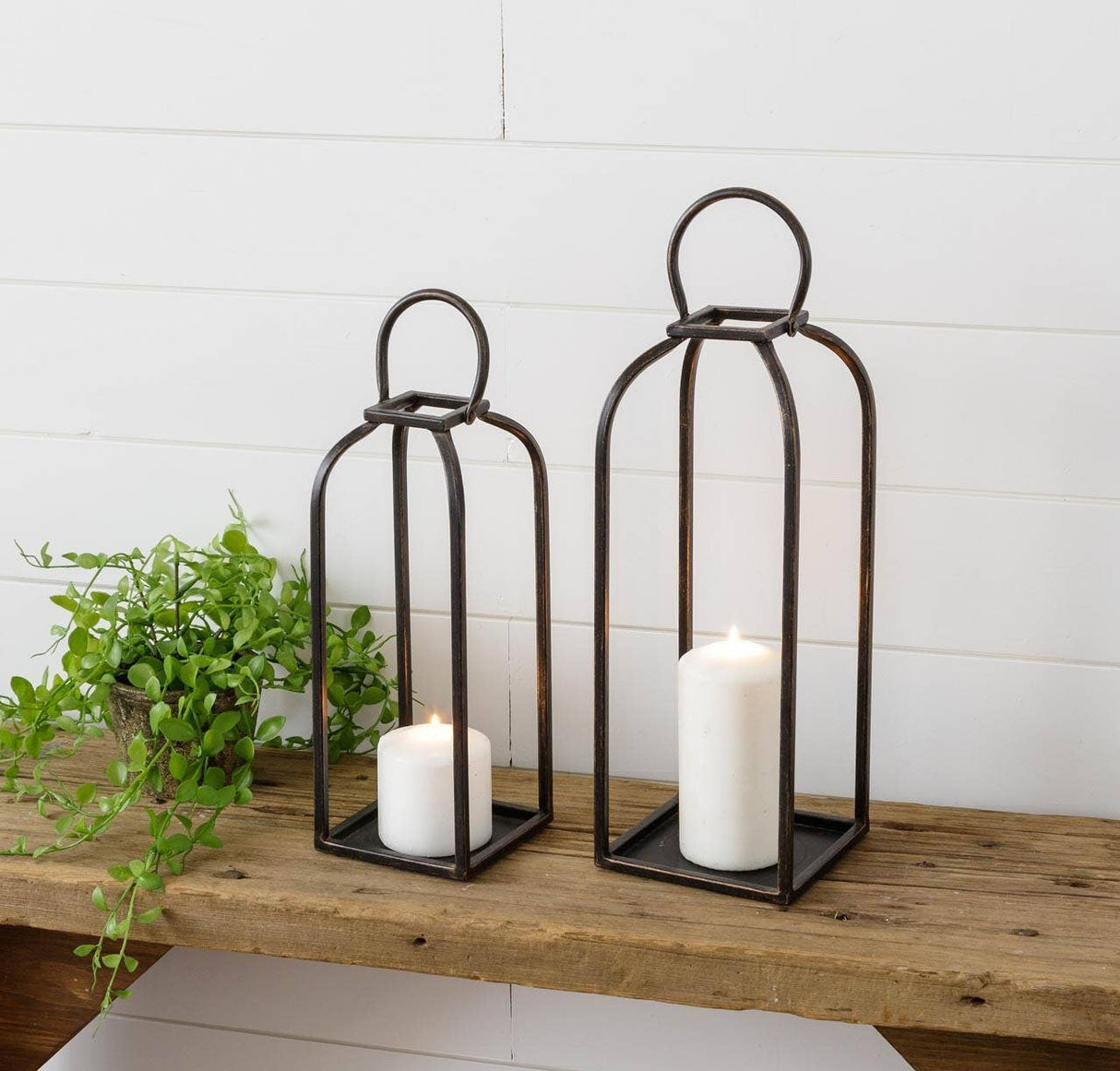 Arched black open metal lanterns styled in a home decor vignette from Magnolias Home Decor