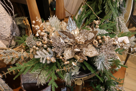 Red and white Christmas mantel display with layered garland, candlesticks, and ribbon accents at Magnolias